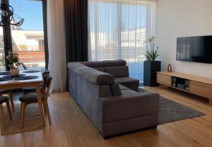a living room with a couch and a chair and a television at Baltiq Plaza Apartment in Gdynia