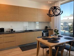 a kitchen with wooden cabinets and a table with chairs at Baltiq Plaza Apartment in Gdynia