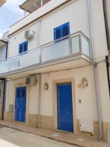 un edificio con una puerta y ventanas azules en Casa Campisi i Mori, en Marzamemi