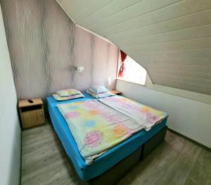 Cama pequeña en habitación pequeña con ventana en Regina Apartman Hegykő, en Hegykő