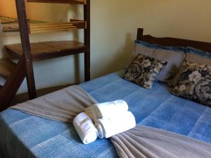 ein Bett mit zwei Rollen Toilettenpapier darauf in der Unterkunft Pousada Rural e Pesqueiro Chalé da serra in Conceição da Ibitipoca