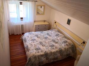 ein Schlafzimmer mit einem Bett, einer Kommode und einem Fenster in der Unterkunft Residence Lago Blù in Pergine Valsugana