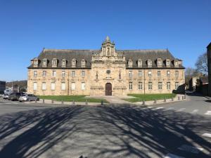 un gran edificio con una gran sombra en la calle en Appartements du Vally - Guingamp, en Guingamp