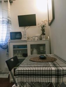 Cette petite chambre dispose d'une table avec une télévision et une table de sidx. dans l'établissement Luxury Apartment Magnolia Terrace, à Fregene