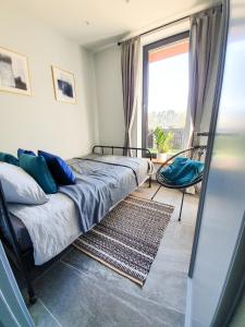 ein Schlafzimmer mit einem Bett und einem großen Fenster in der Unterkunft atPUUTA in Saulkrasti