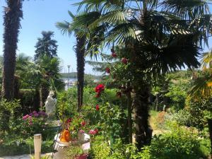 a garden with palm trees and a statue and flowers at Villa Marija in Vrsar