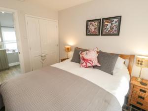 1 dormitorio con 1 cama blanca grande y 2 lámparas en Marlin Cottage en Conwy