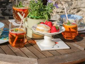 a table with a bowl of strawberries and drinks at Marlin Cottage in Conwy