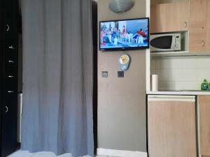 einen TV an der Wand in einer Küche mit einer Küche in der Unterkunft Californie Appartement in Nizza