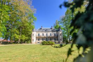 une grande maison sur un grand champ herbeux dans l'établissement Château de la villeneuve, à Saint-Marcel