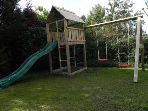 a playground with a slide and swings in a yard at Ferienwohnung Stryck in Tettnang
