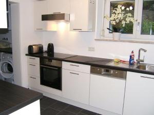 a kitchen with white cabinets and a sink at Ferienwohnung Stryck in Tettnang