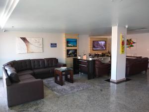 uma sala de estar com dois sofás e uma cozinha em Aconchegante Apartamento com Vista para o Mar e Nascer do Sol em Arraial do Cabo