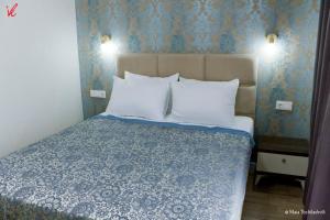 Ce lit se trouve dans un dortoir doté d'un mur bleu. dans l'établissement Sameba Bell, Luxury Apartment, à Tbilissi