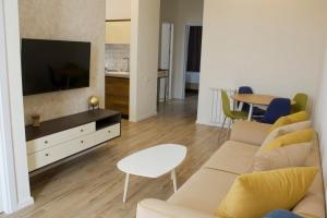 - un salon avec un canapé, une télévision et une table dans l'établissement Sameba Bell, Luxury Apartment, à Tbilissi