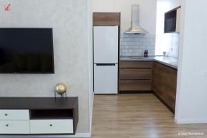 a kitchen with a white refrigerator and a tv at Sameba Bell, Luxury Apartment in Tbilisi City
