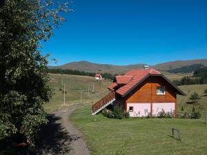 a small house with a red roof on a field at Apartment Studenac in Zlatibor