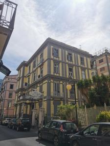 卡斯特拉玛雷帝斯达比亚Le Stanze di Eli e Giò的一座黄色的建筑,前面有汽车停放