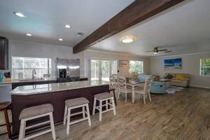 a kitchen with a bar with stools and a table at Heated Pool Home - Close to Beaches, Restaurants & More! in Sarasota