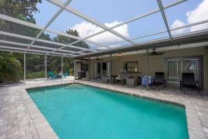 a swimming pool with a pergola over it at Heated Pool Home - Close to Beaches, Restaurants & More! in Sarasota