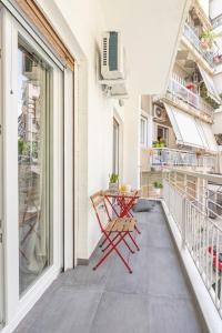 balkon z czerwonym krzesłem i stołem w obiekcie Ports Crossroad E w Pireusie
