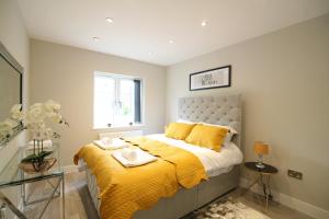 a bedroom with a bed with a yellow blanket at NEW - Stylish 2 bed, Farnham Common in Hedgerley