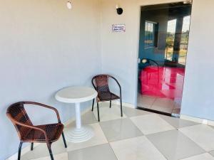 dwa krzesła i stół w pokoju w obiekcie Juventus Residence w mieście Goiânia