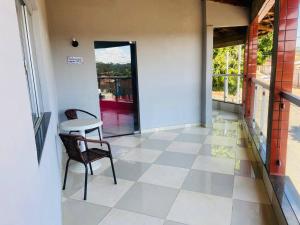 een kamer met een tafel en stoelen op een tegelvloer bij Juventus Residence in Goiânia