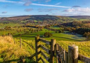 a fence on a hill with a view of a valley at Old Hall cottage in Hope