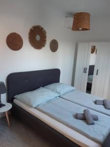 a bedroom with a bed with blue sheets and a mirror at APARTMAN SOÓS -- Only for relaxation, not for party! in Siófok