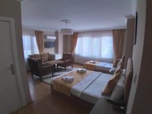 um quarto de hotel com uma cama e uma sala de estar em NEW BEYLERBEYİ HOTEL em Istambul