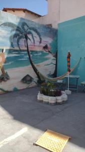 a painting of a hammock and a palm tree on a wall at MAR DOCE LAR in Cabo Frio