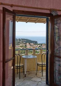a balcony with a table and chairs and a window at Rizos Veranda - Rooms in Isómata