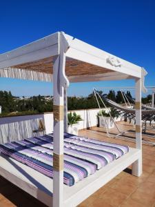 a white bed on a deck with a roof at Casa Silca in Marbella