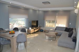 un soggiorno con divano e tavolo di ''Stergiou Luxury Apartments'' με κοινη πισινα a Saronida
