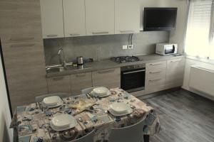 a kitchen with a table with chairs and a sink at Agriturismo La Fraterna in Tolle