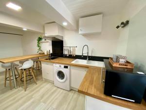 une cuisine avec un évier et une machine à laver dans l'établissement Le Cosy City - Agde Centre, à Agde
