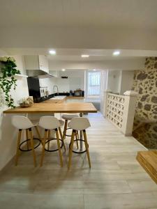 cocina con mesa de madera y taburetes en Le Cosy City - Agde Centre en Agde