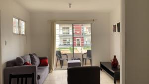a living room with a couch and a table with chairs at Like Home Apartment !!! 2 bedrooms full apartment in La Ureña