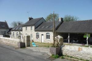 una casa di mattoni bianchi con un muro di pietra di 16Bis 1ch, 2-4pers, jardin Les Gîtes Bigoudens a Plonéour-Lanvern