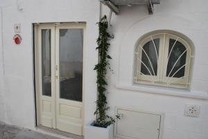 um edifício branco com uma porta e uma janela em Casetta Melograno em Fasano