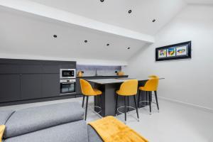 a kitchen with a couch and a table with yellow chairs at Winter Garden Apartments by Sasco in Blackpool