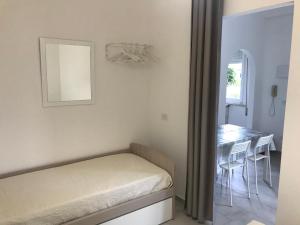- une chambre avec un lit et une table avec des chaises dans l'établissement Apartment B - Green Marine, à Silvi Marina
