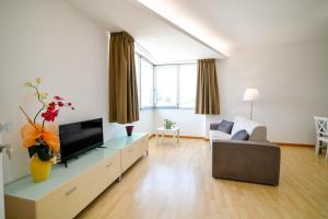 salon z telewizorem i kanapą w obiekcie Villa Laura Charme Apartments w mieście Avola