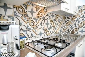 kuchnia z kuchenką i wzorzystą ścianą w obiekcie Villa Laura Charme Apartments w mieście Avola