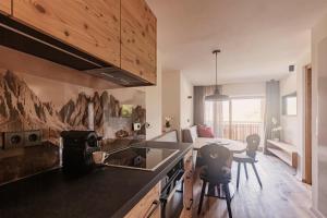 a kitchen with a counter and a table and chairs at Wanderhotel Teiserhof in Funes