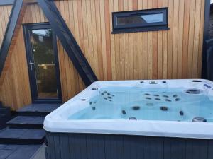 a jacuzzi tub sitting next to a house at Little Woodbine in Tain