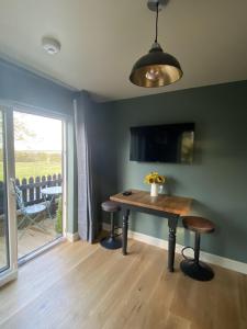 a dining room with a table and a balcony at Little Woodbine in Tain