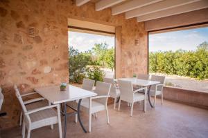a dining room with tables and chairs and a large window at Agroturismo Can Pere Rei in Son Serra de Marina +23 photos