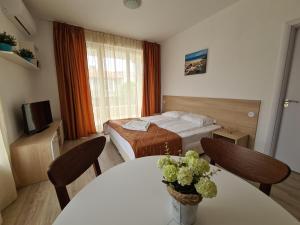 um quarto de hotel com uma cama, uma mesa e cadeiras em MIDA Apartment em Obzor
